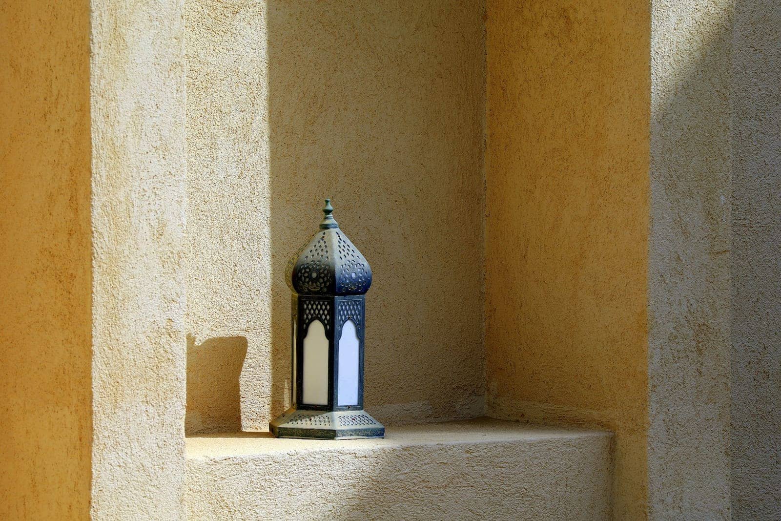 Moroccan lantern set in a niche with ochre walls