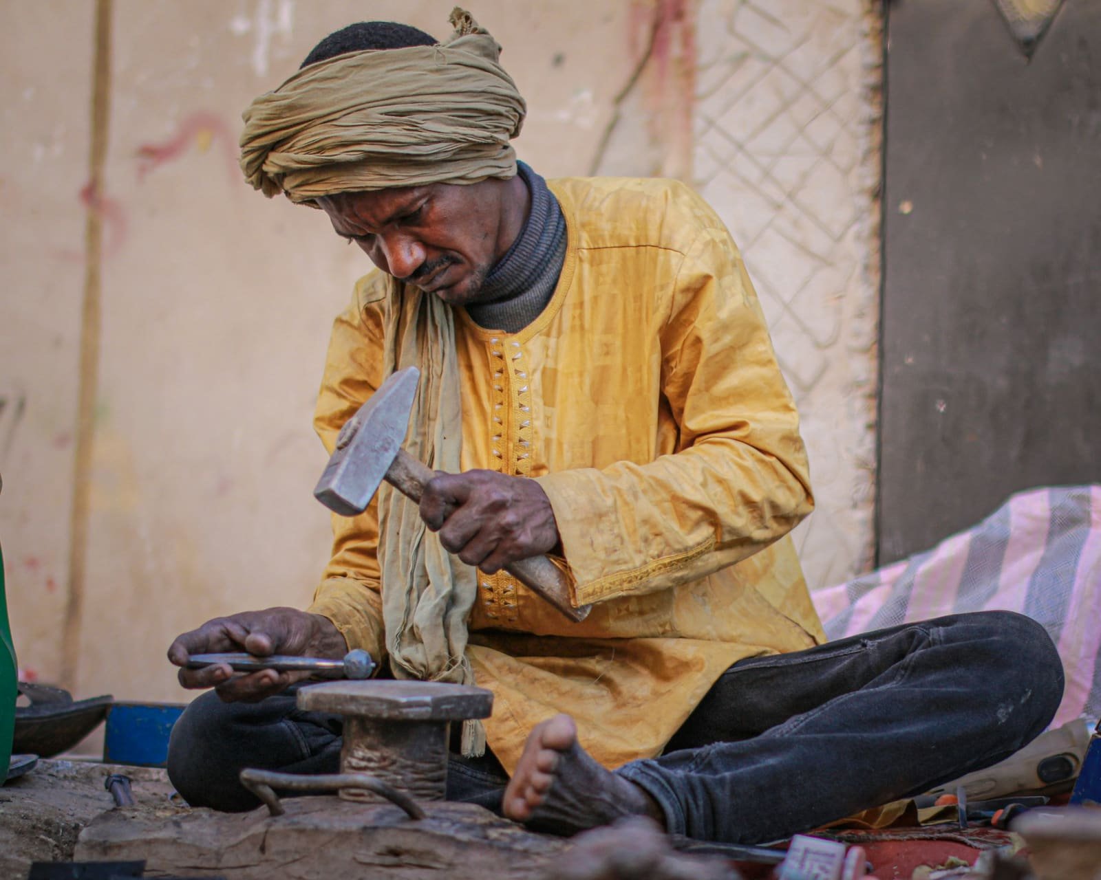 Moroccan craftsman working metal, seated on the floor