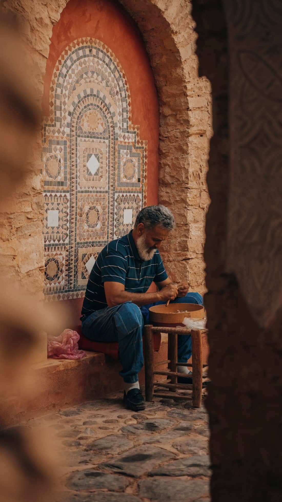Craftsman at work in front of a zellige-decorated door