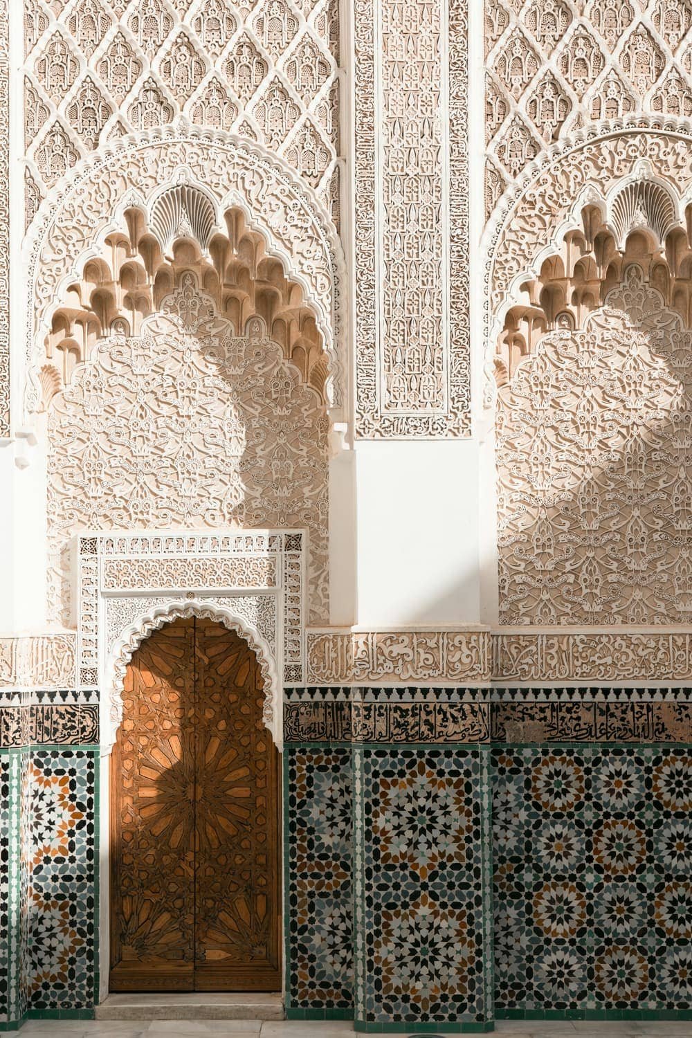 Carved wooden door framed with plaster and zellige