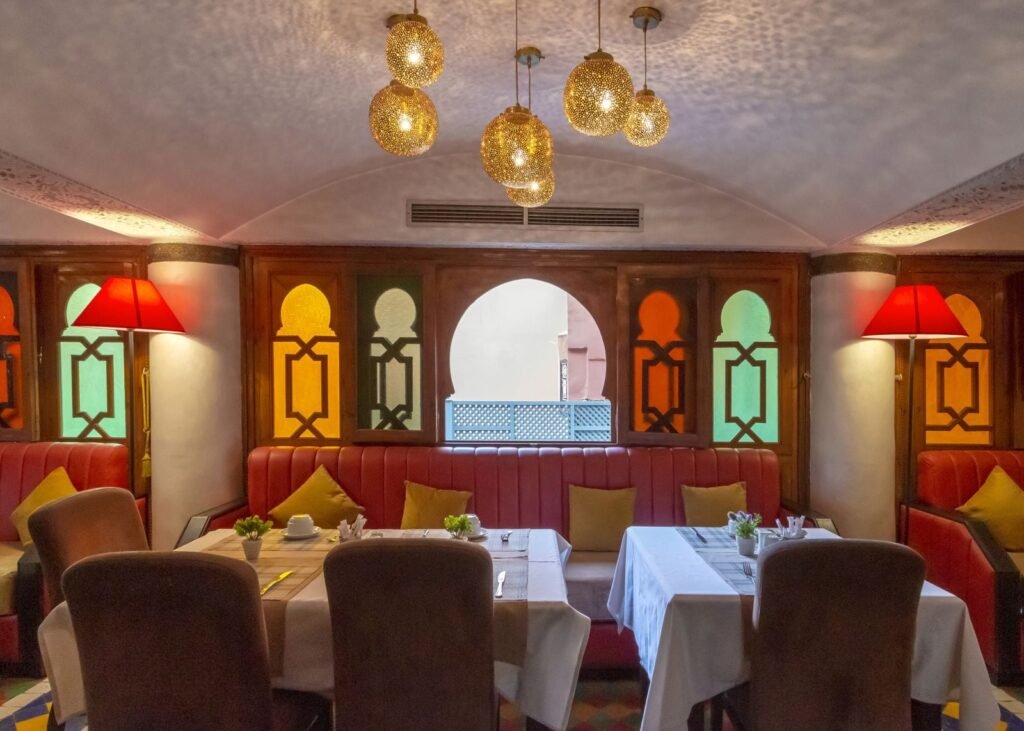 Salle de restaurant de l’Hôtel Le Caspien, vitraux colorés et lanternes en laiton