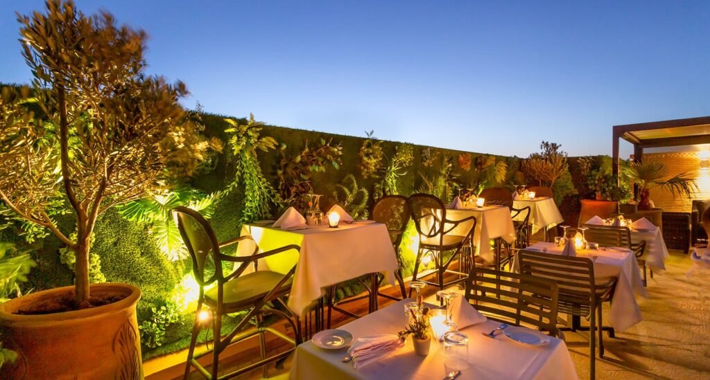 Terrasse de l’Hôtel Le Caspien dressée pour le dîner, au crépuscule
