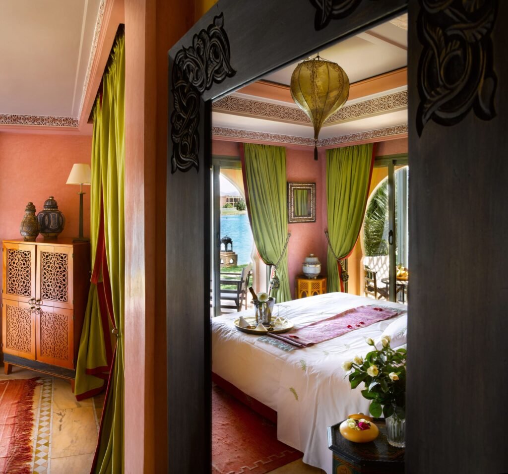 Chambre d’une suite vue à travers une porte en bois sculpté
