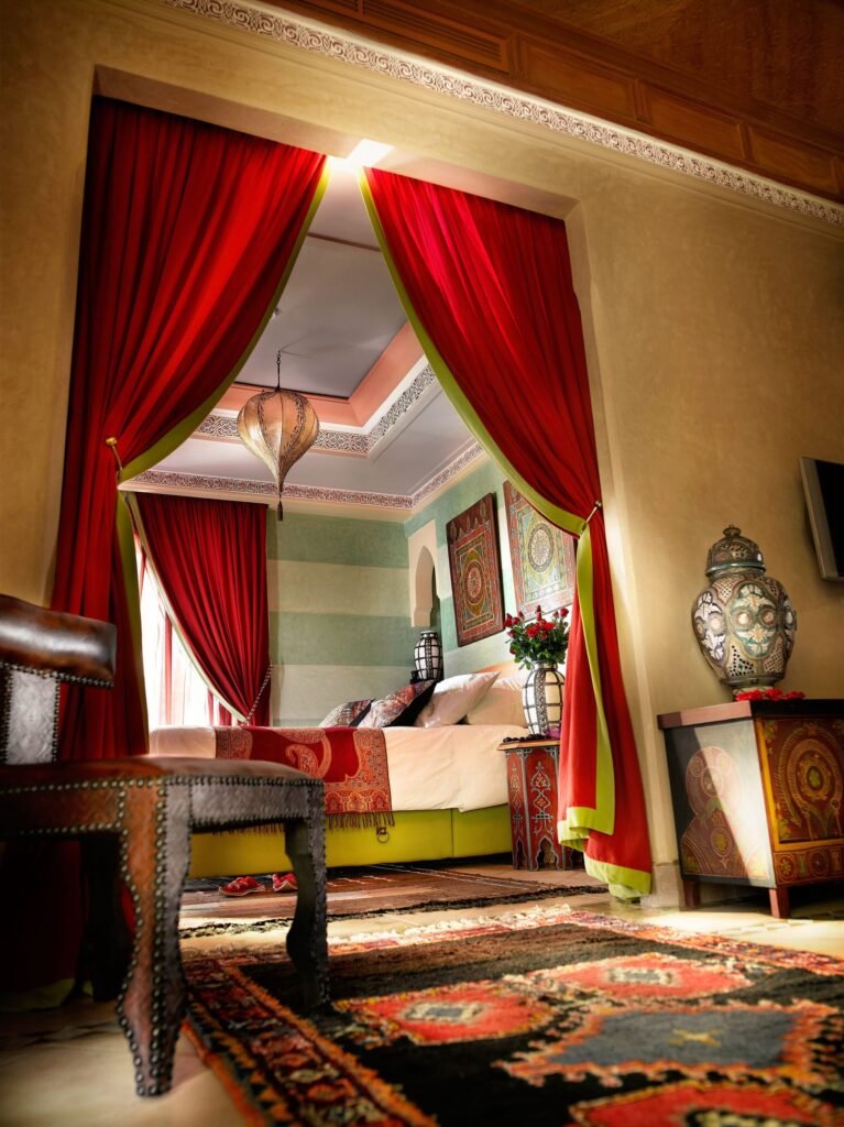 Chambre d’une suite du Pavillon du Golf, rideaux rouges et tapis