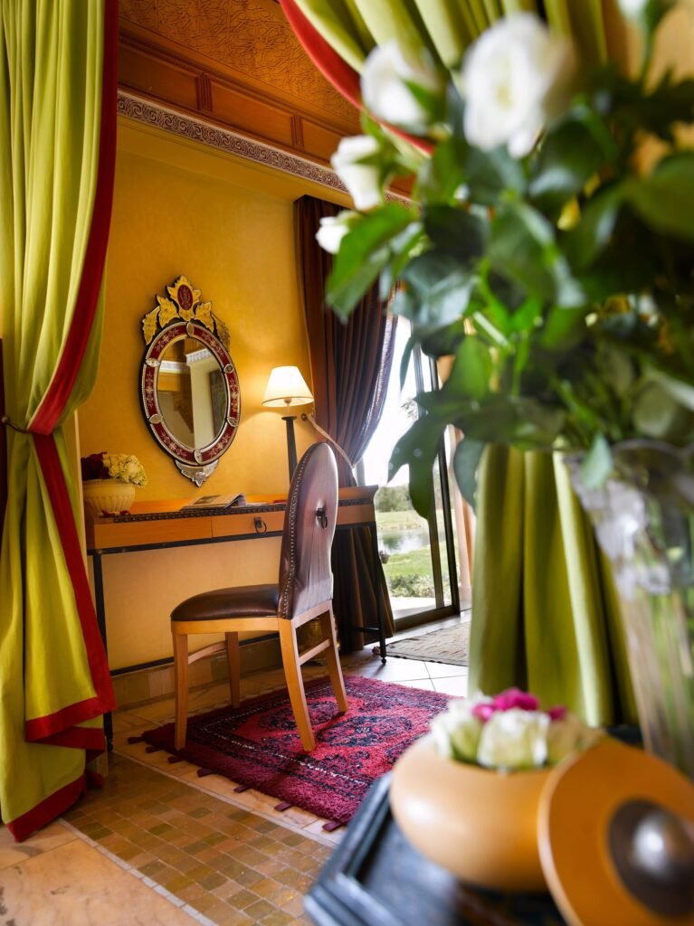 Détail d’une suite du Pavillon du Golf : tentures vertes, miroir et bouquet