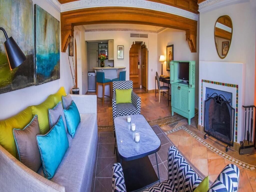 Salon d’une suite du Pavillon du Golf avec cheminée et coin cuisine
