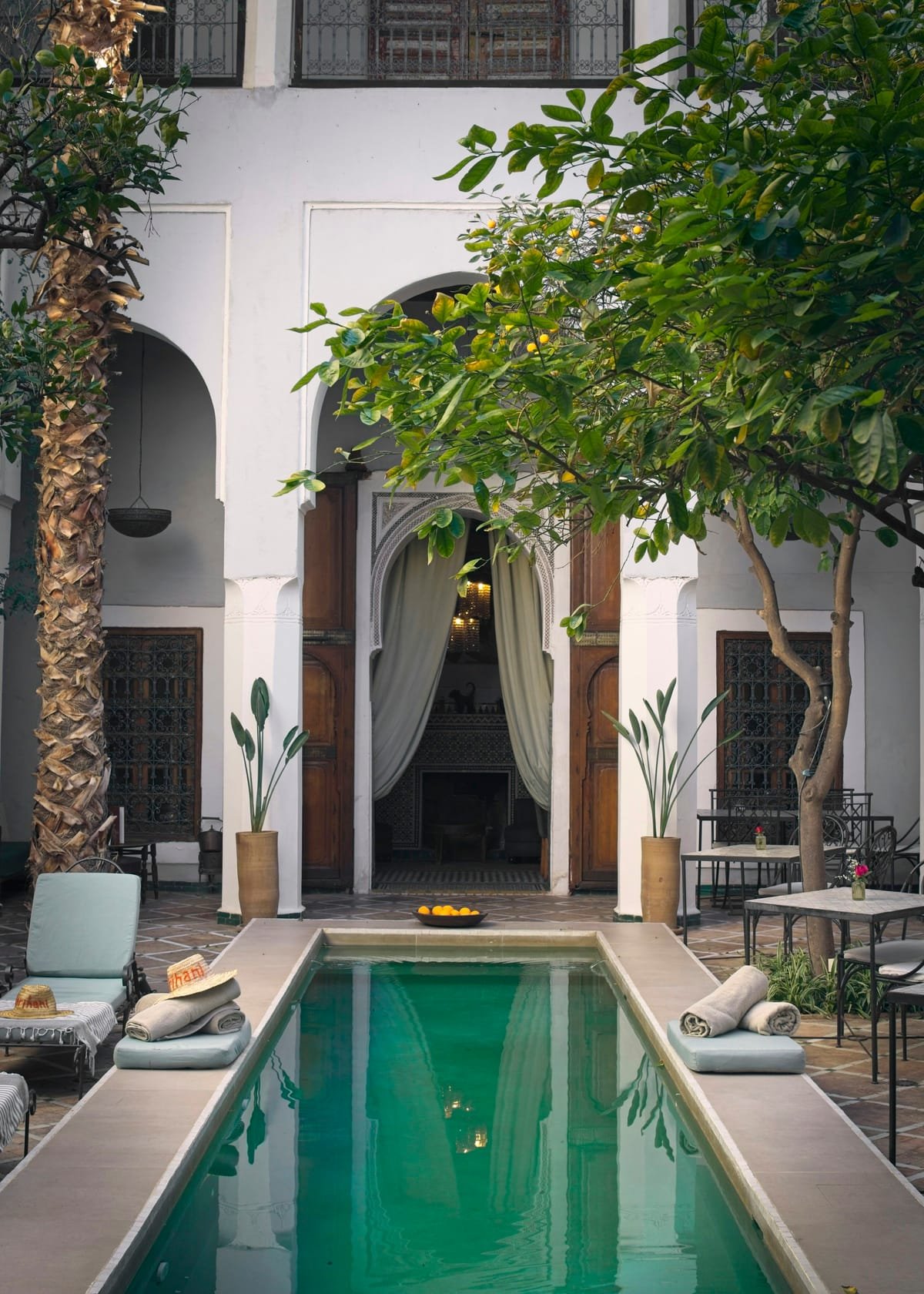 Patio de riad avec bassin, arcades et salon extérieur
