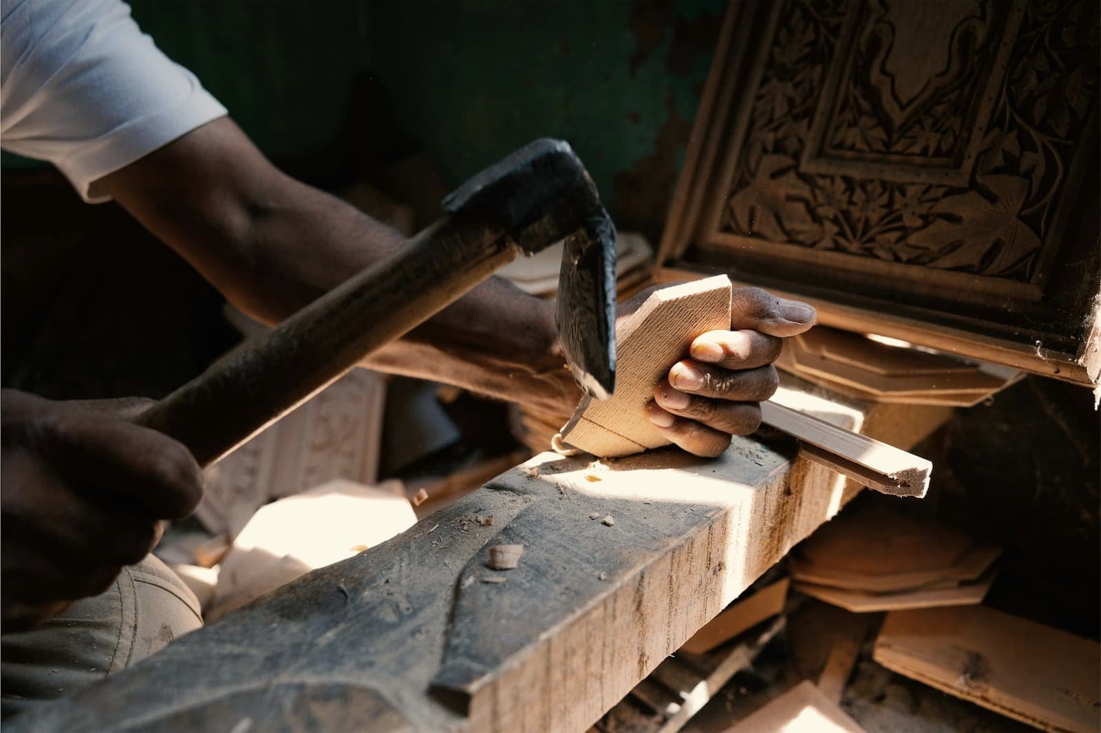 Craftsman’s hands carving a piece of wood