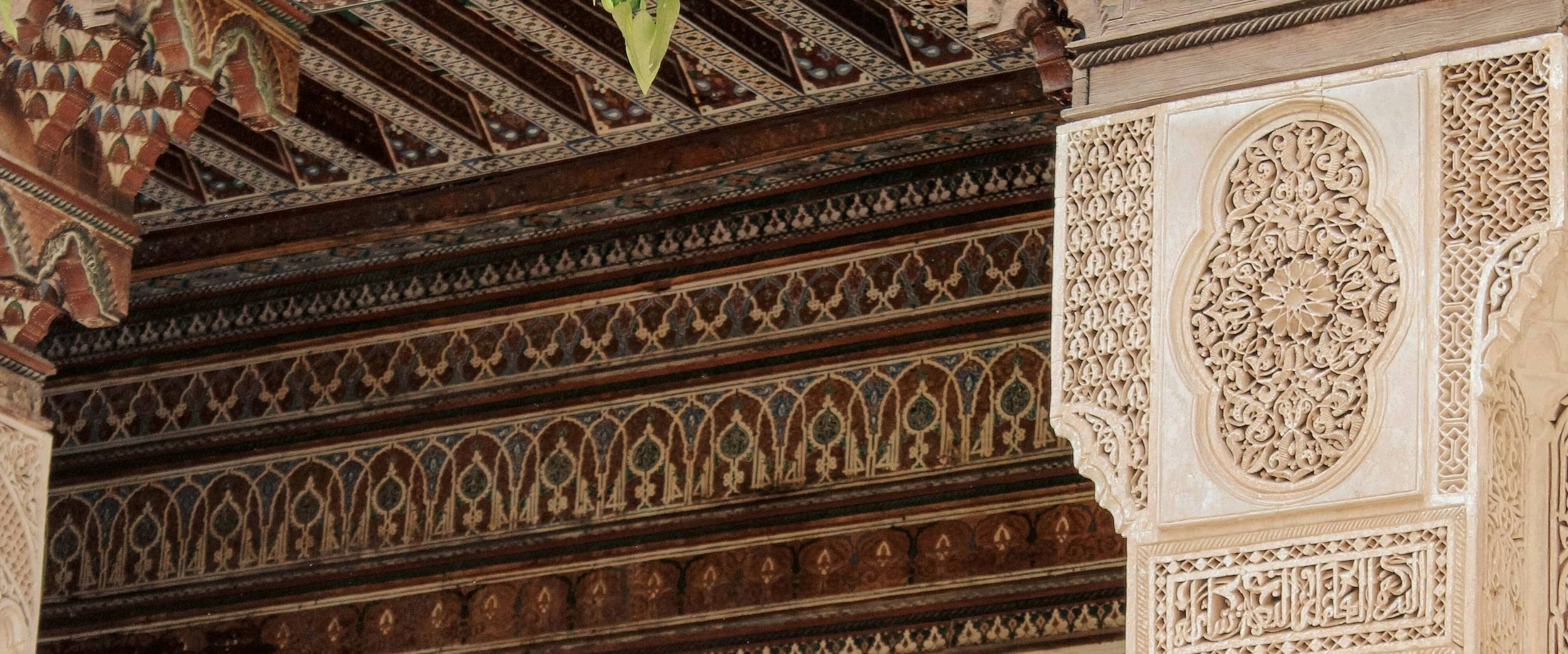 Carved and painted cedar ceiling above a plaster frieze